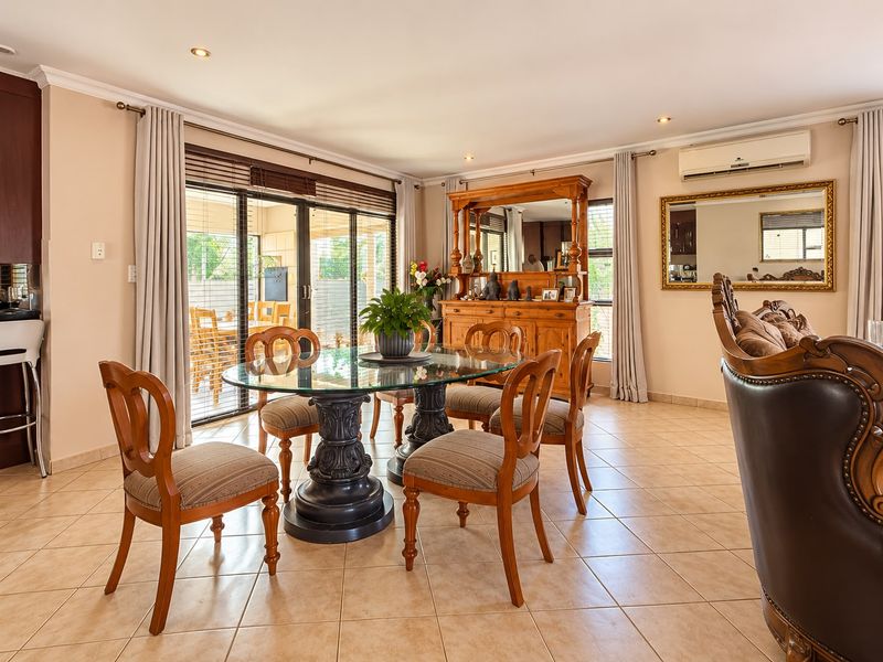 A spacious dining area featuring tiled flooring, recessed lighting, and large sliding glass doors that provide access to the outdoor patio area.