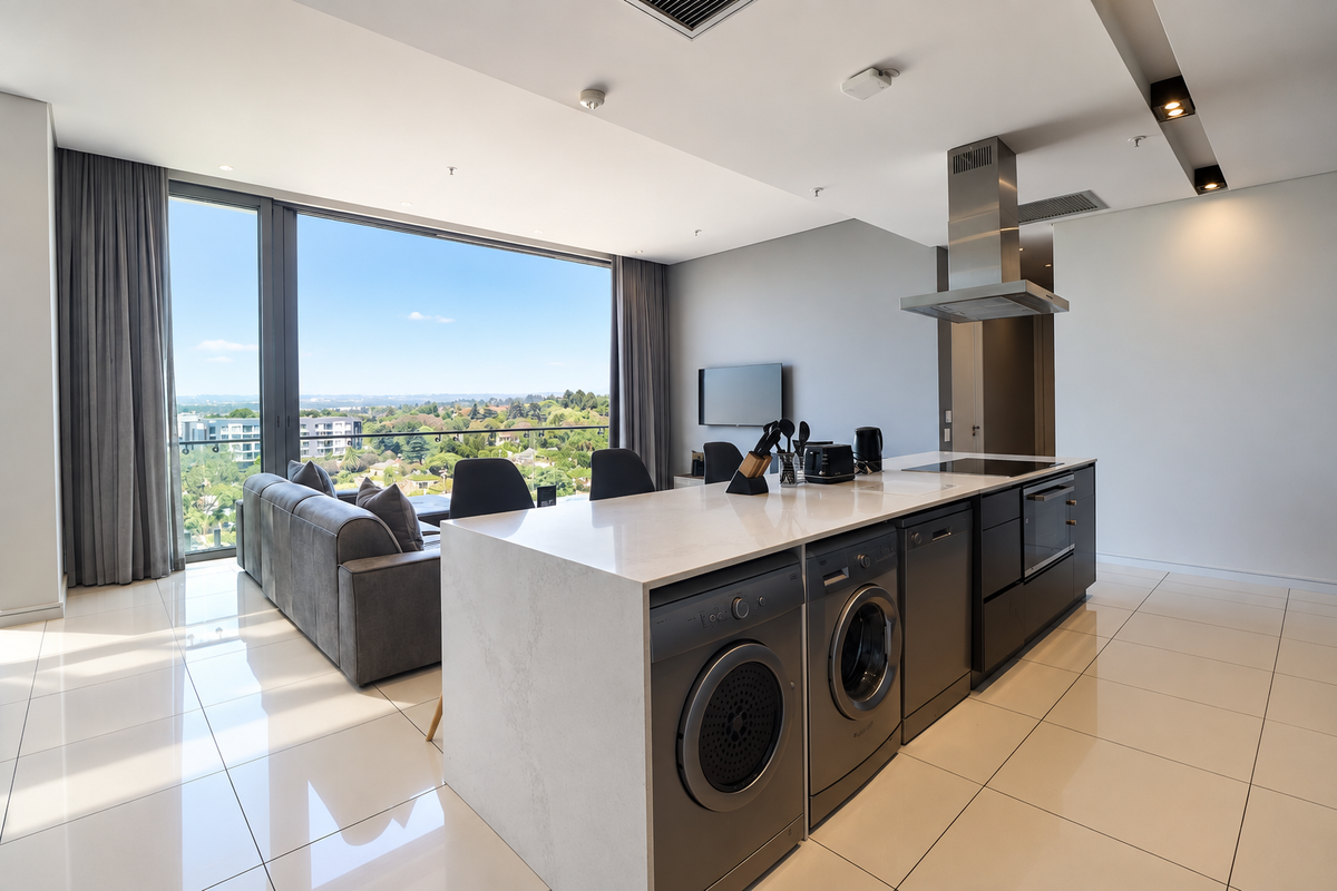 Modern open-plan living area featuring a sleek kitchen island with integrated appliances, high-gloss floor tiles, and expansive windows offering panoramic views.