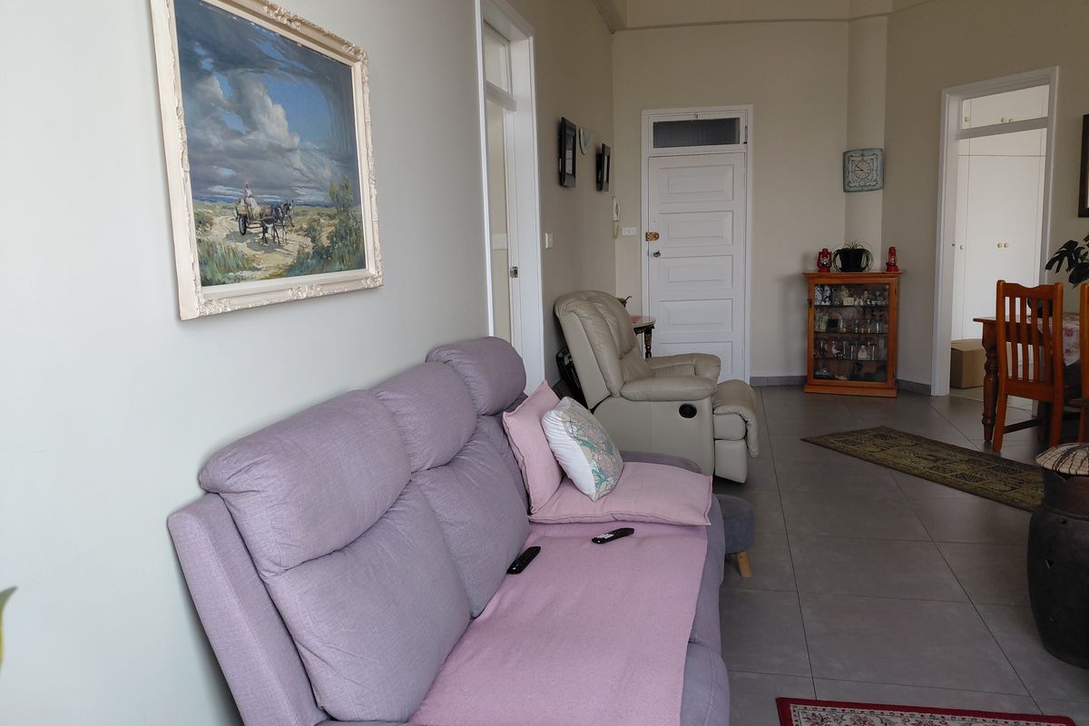 A living room area featuring tiled flooring and classic panelled interior doors, providing a neutral base for potential interior updates.