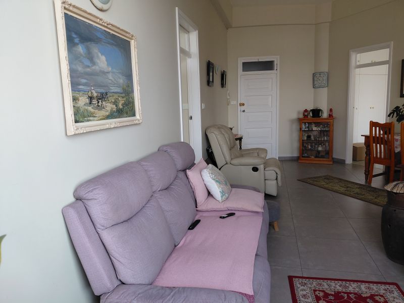A living room area featuring tiled flooring and classic panelled interior doors, providing a neutral base for potential interior updates.