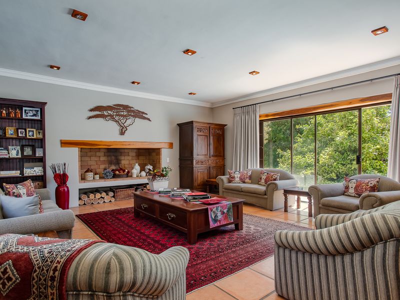 Spacious living room featuring a built-in brick fireplace, tiled flooring, and large sliding glass doors that provide ample natural light and garden views.