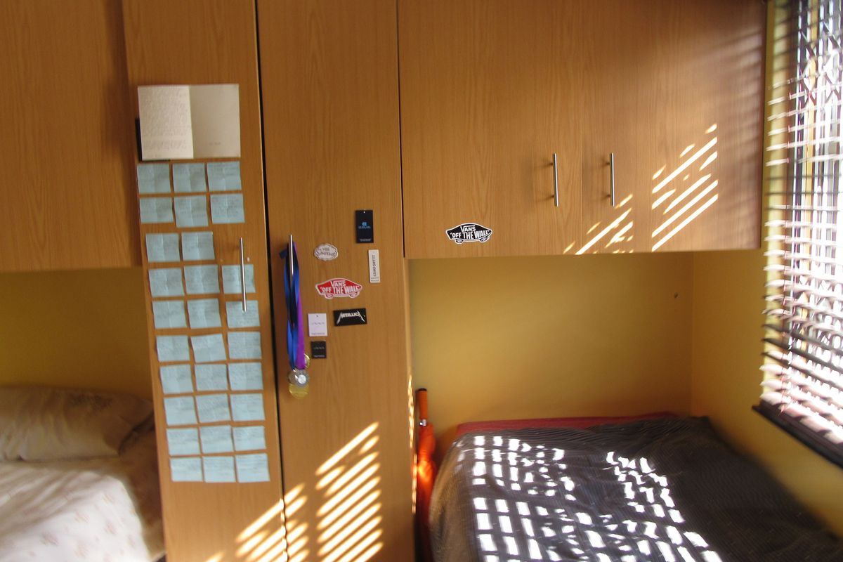 Bedroom featuring built-in wooden cabinetry and venetian blinds, providing functional storage and natural light control.