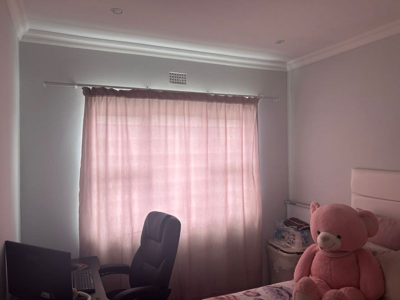 A bedroom featuring recessed downlights, decorative ceiling cornicing, and a ventilation grille, providing a functional and comfortable living space.