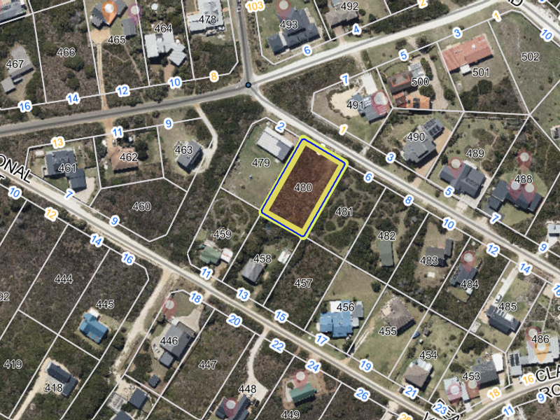 Aerial view of a vacant residential land plot in a developed coastal neighborhood, highlighting the property boundaries and surrounding infrastructure.