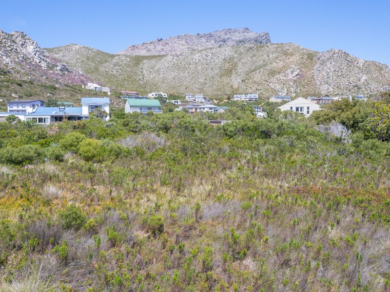 A scenic view of the residential area and surrounding mountain landscape from the vacant land plot.