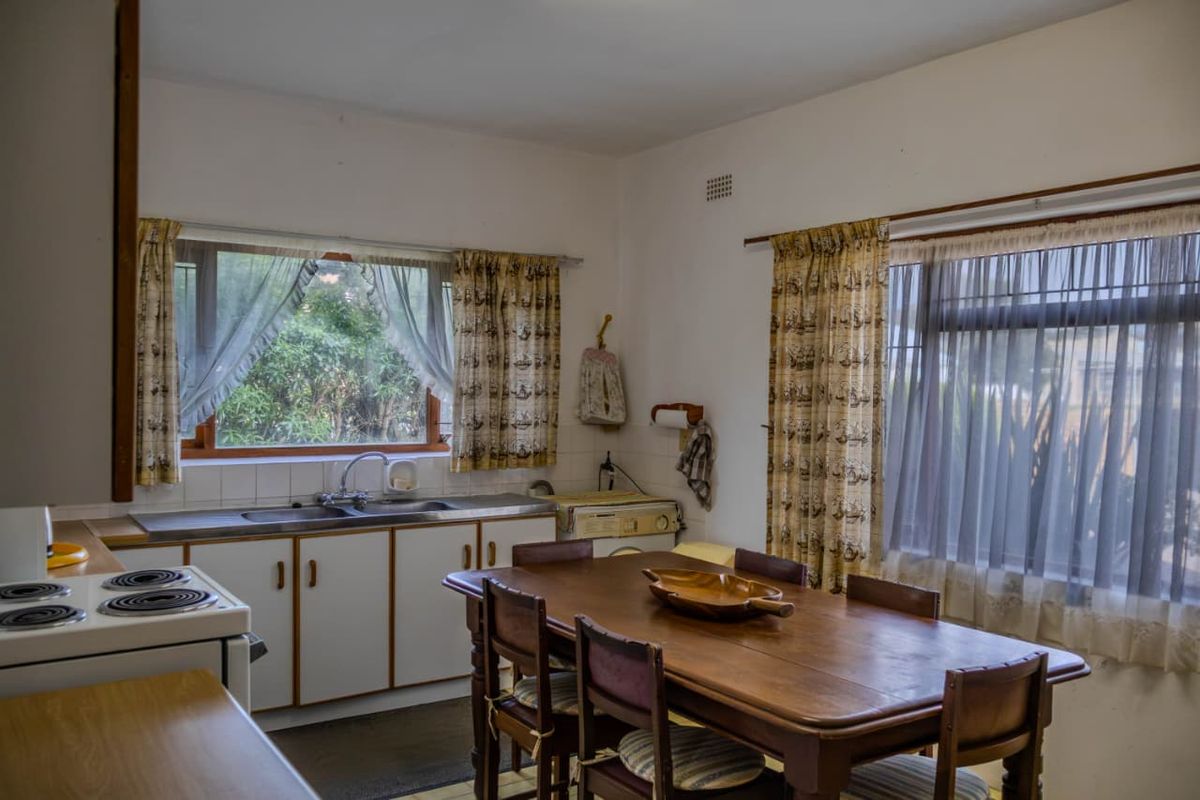 A functional kitchen featuring built-in cabinetry, a stainless steel sink, and an electric stove, offering potential for modernization and renovation.