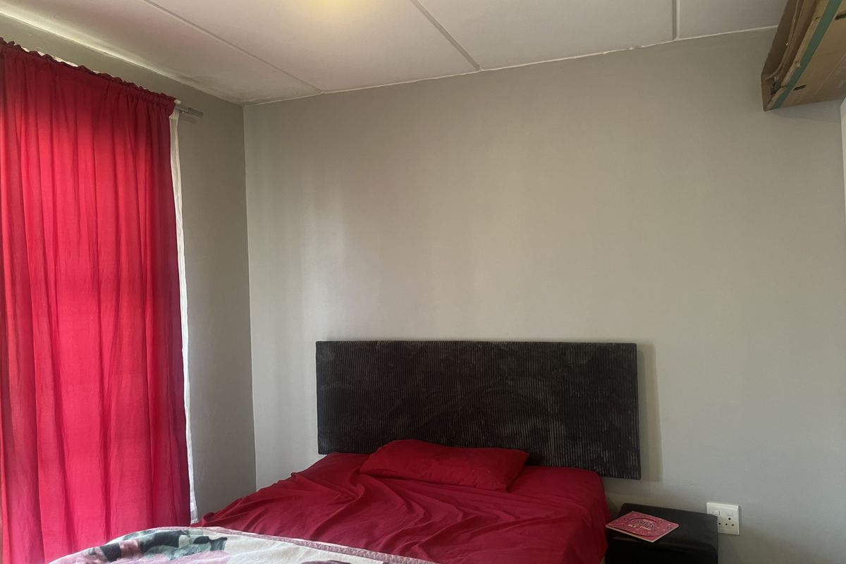 A bedroom featuring neutral wall tones and standard ceiling tiles, offering a functional space ready for personalization and cosmetic updates.