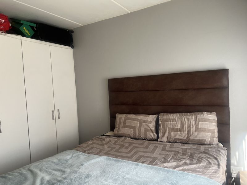A bedroom featuring a built-in wardrobe with white cabinetry and neutral wall finishes.