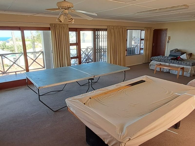 Spacious living area featuring large sliding glass doors with access to a balcony, ceiling fan, and neutral carpeting throughout.