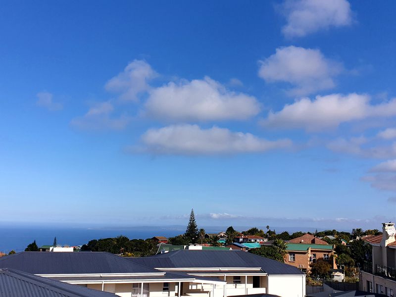 Elevated panoramic view overlooking the surrounding neighborhood with a clear outlook towards the distant coastline and ocean.