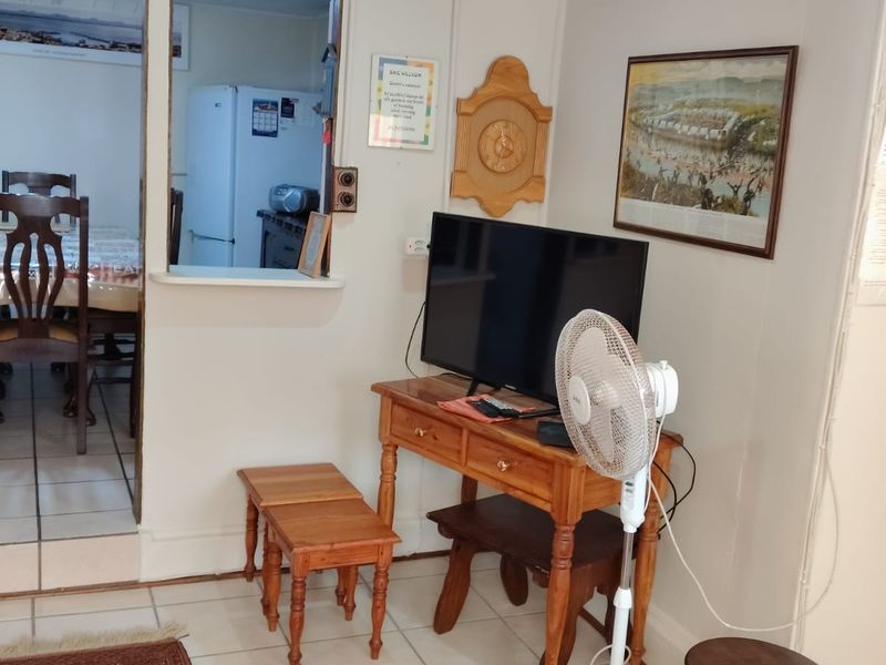 A living area featuring tiled flooring and a convenient pass-through window connecting to the adjacent dining space.
