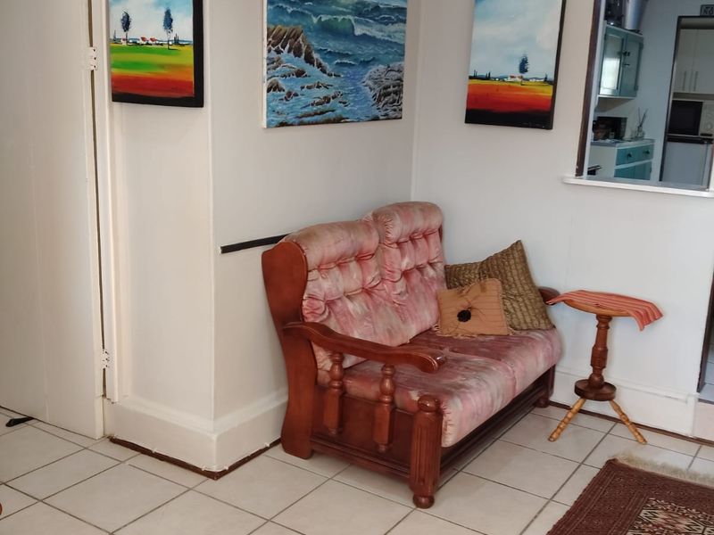 A living area featuring tiled flooring and a convenient serving hatch connecting to the kitchen space.