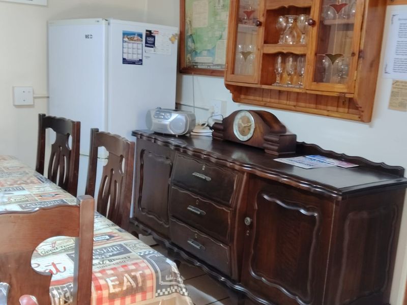 A dining area featuring tiled flooring and a wall-mounted wooden display cabinet, providing a functional space for meals and storage.