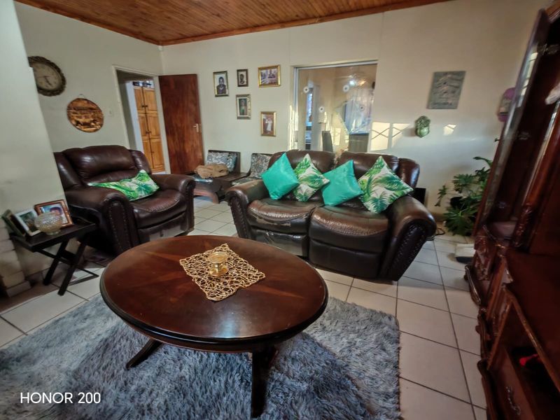 A living room featuring tiled flooring and a timber ceiling, providing a functional space with potential for modern updates.