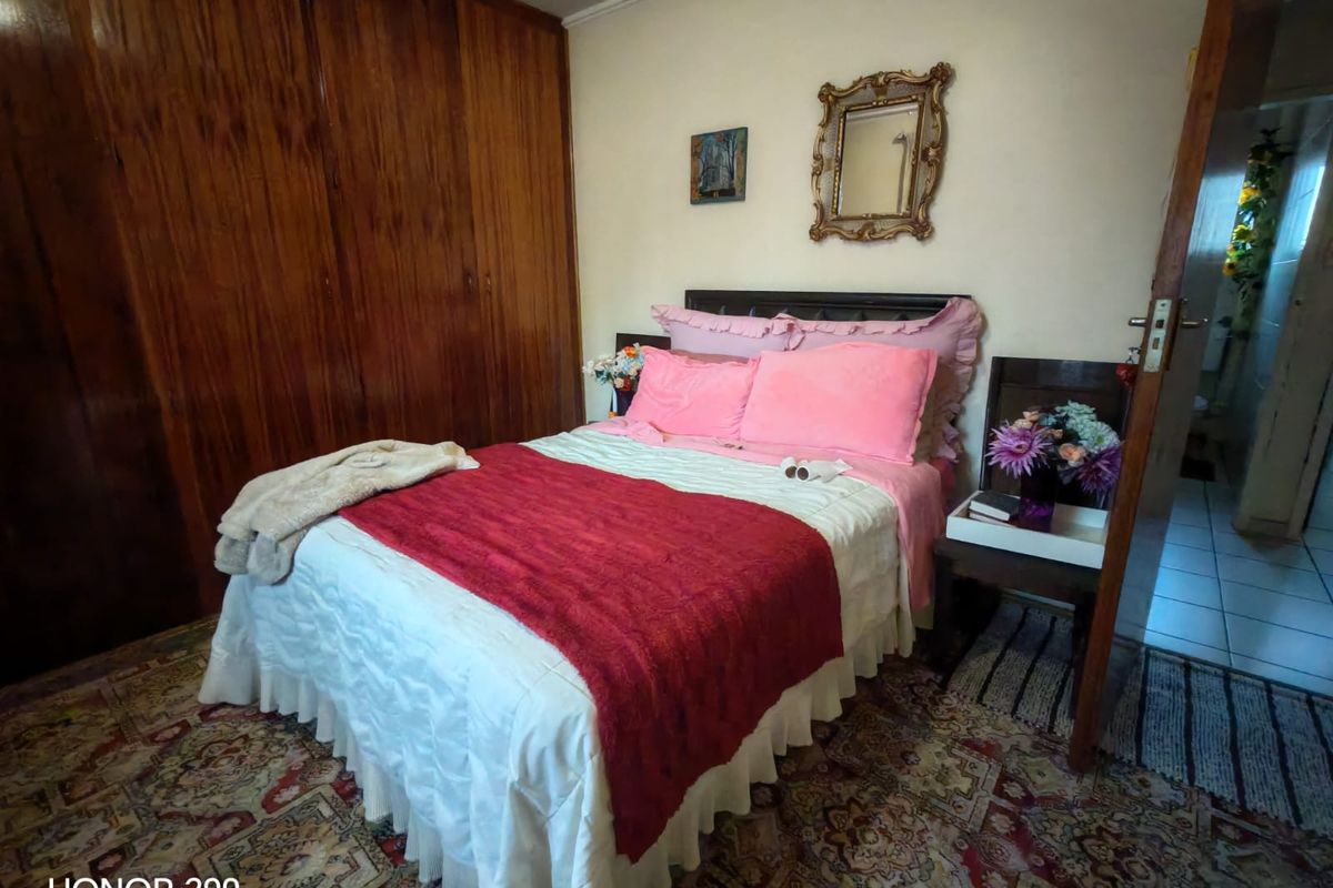 A bedroom featuring built-in wooden cupboards and traditional flooring, offering a functional space with potential for modern updates.
