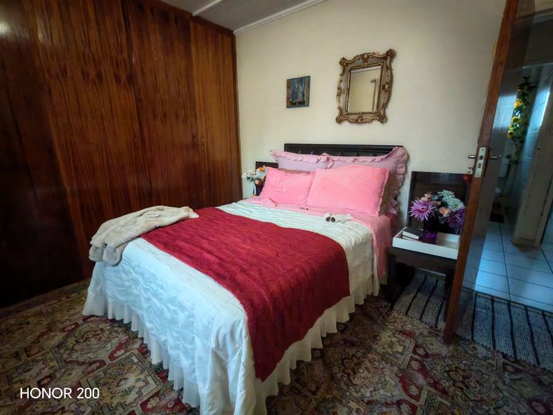 A bedroom featuring built-in wooden cupboards and traditional flooring, offering a functional space with potential for modern updates.