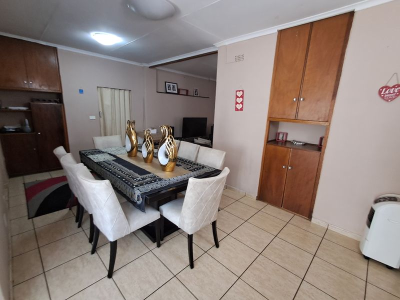A dining room featuring tiled flooring and built-in wooden cabinetry, providing a functional space for family meals and gatherings.