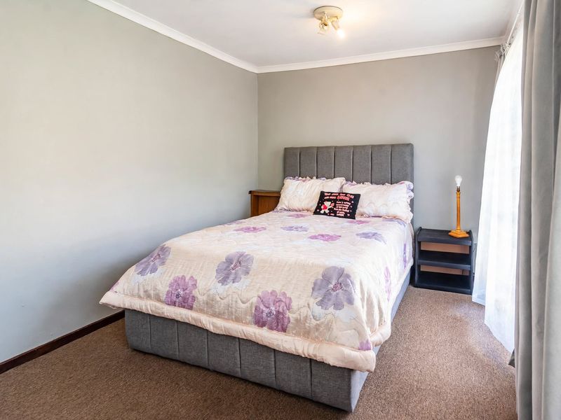 A standard bedroom featuring neutral wall paint, carpeted flooring, and a ceiling light fixture, providing a functional and comfortable living space.
