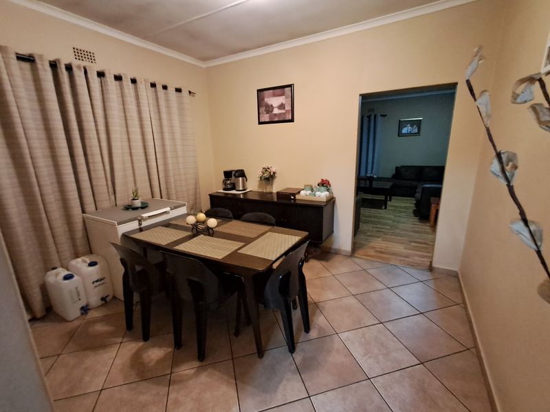 A functional dining area featuring ceramic tile flooring and coved ceiling cornices, with an open transition into the adjacent living space.