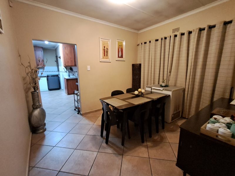 Dining room featuring ceramic floor tiles and an open archway leading to the kitchen area.