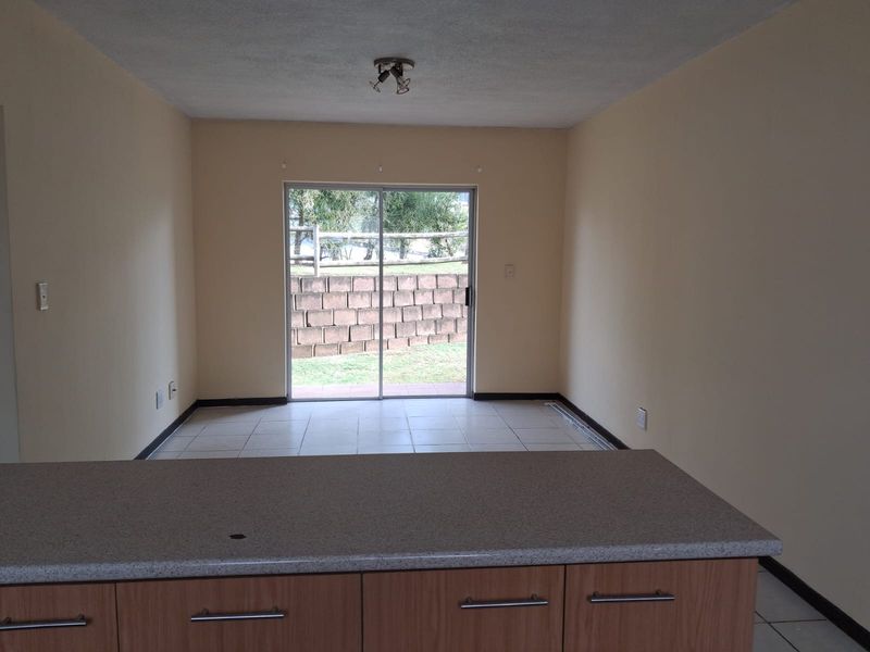 Open plan living area featuring a kitchen island with cabinetry and sliding glass doors leading to the exterior.