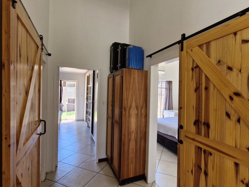 A hallway featuring wooden sliding barn doors and tiled flooring, providing access to adjacent rooms within the townhouse.