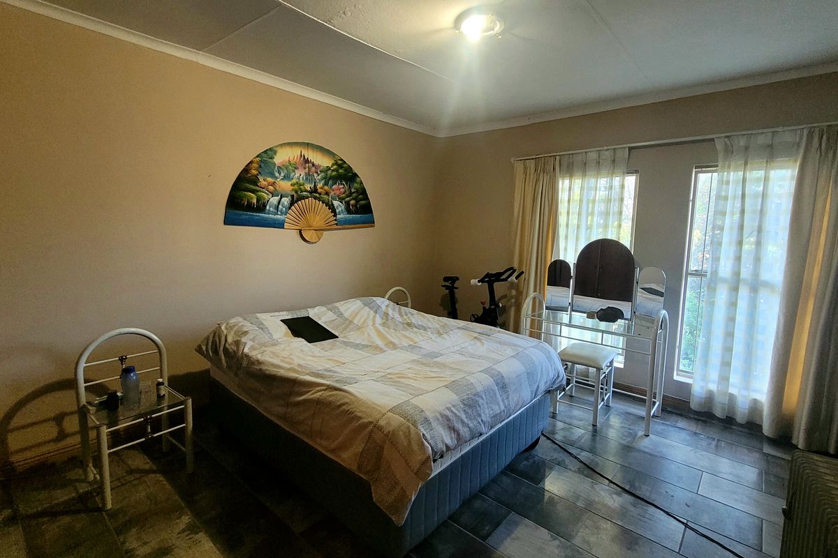 A spacious bedroom featuring tiled flooring and large windows with curtain tracks, offering a functional layout ready for modern updates.
