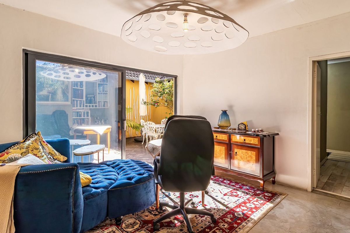 A bright living area featuring polished concrete floors and large sliding glass doors that provide seamless access to the outdoor patio space.