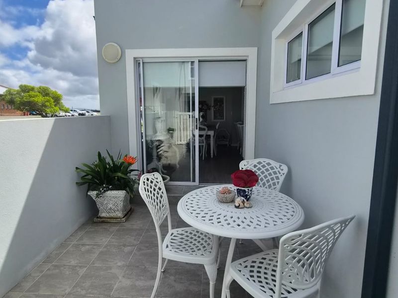 A well-maintained outdoor patio area featuring tiled flooring and a sliding glass door providing access to the interior living space.