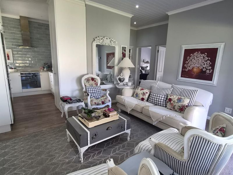 An open-plan living area featuring a modern kitchen with subway tile backsplash, integrated appliances, and a bright, well-maintained living space with recessed lighting.