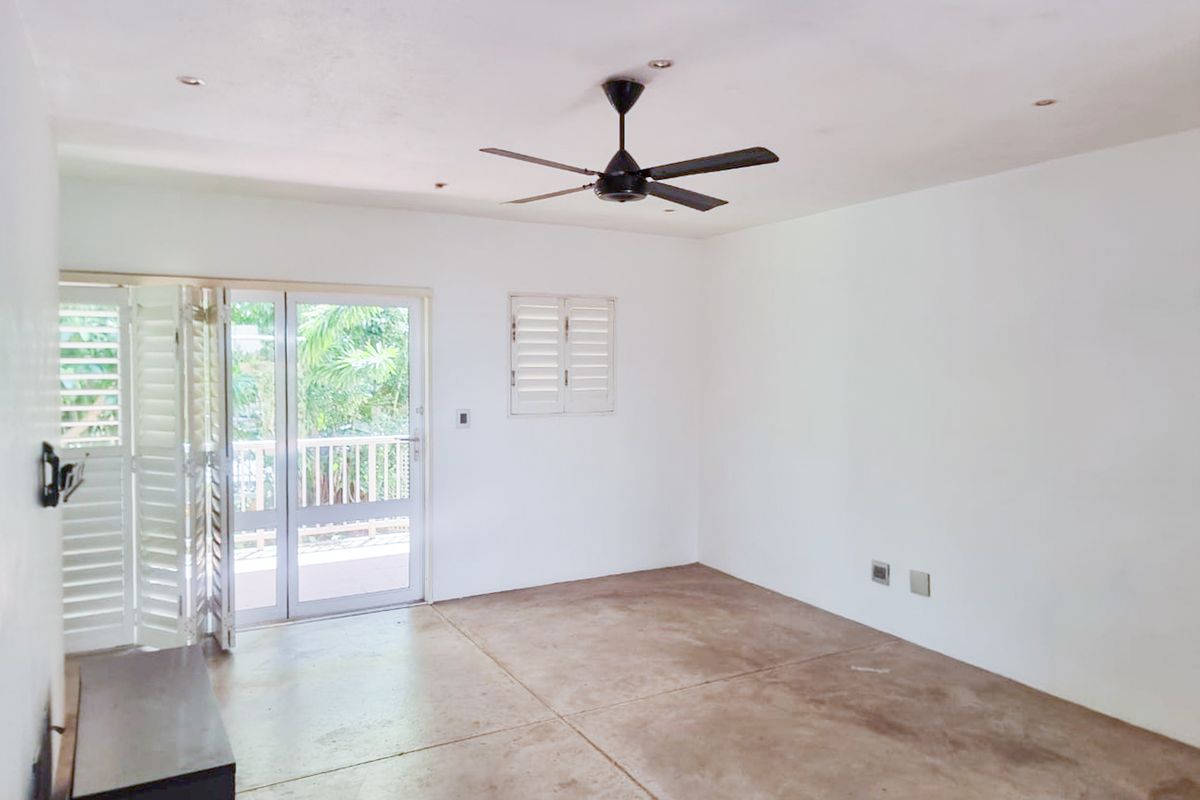 An empty living room featuring concrete flooring, a ceiling fan, recessed lighting, and glass french doors opening to an outdoor area.