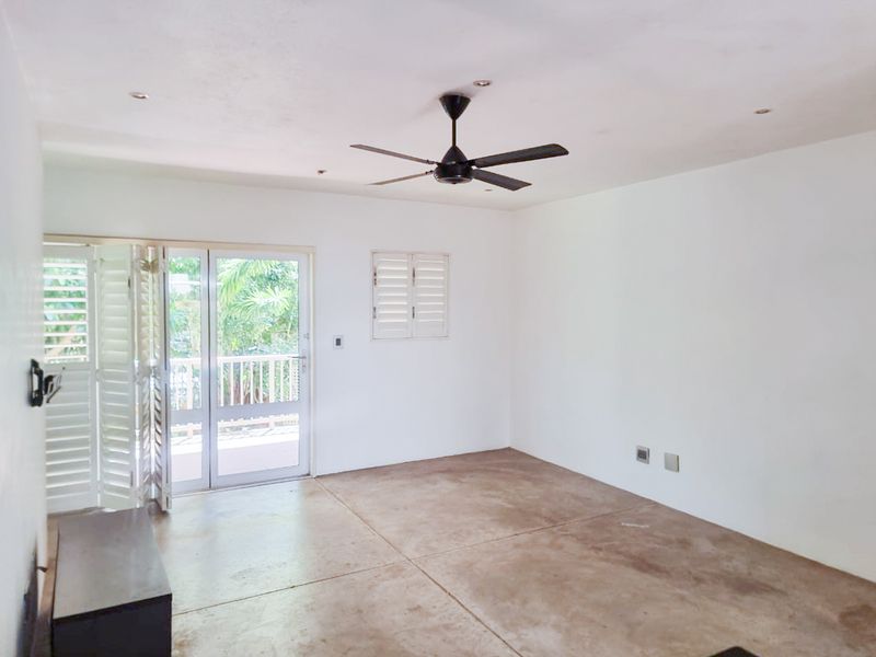 An empty living room featuring concrete flooring, a ceiling fan, recessed lighting, and glass french doors opening to an outdoor area.