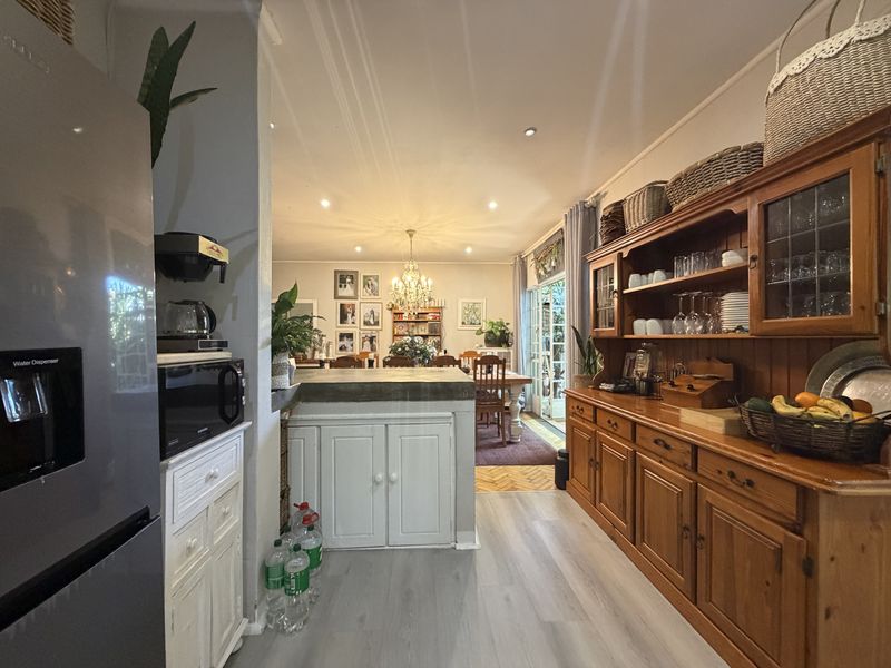 Open plan kitchen and dining area featuring built-in wooden cabinetry, concrete countertops, and direct access to the outdoor patio through sliding glass doors.