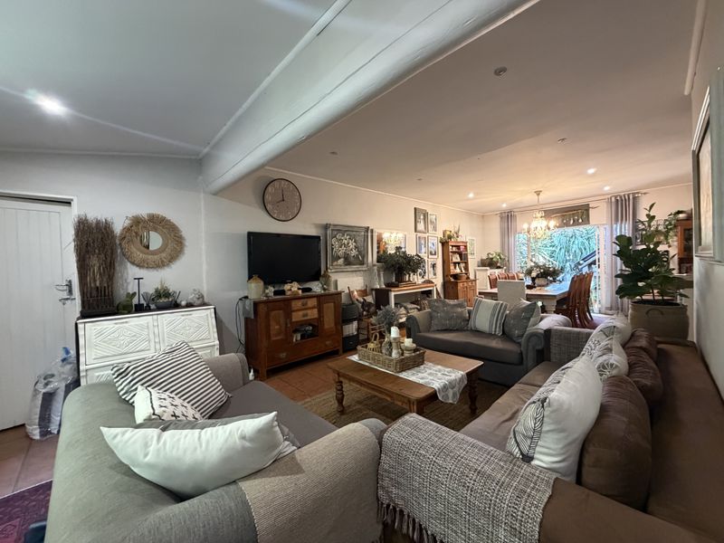 Spacious open-plan living and dining area featuring tiled flooring, recessed lighting, and large sliding doors providing access to the outdoor space.