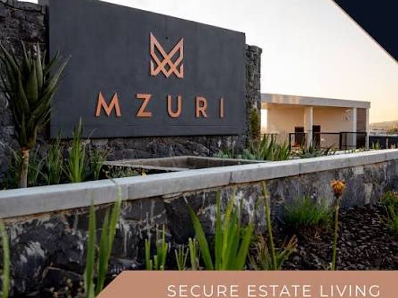A modern estate entrance featuring stone masonry walls, professional landscaping, and prominent Mzuri estate signage, reflecting a secure and well-maintained residential environment.