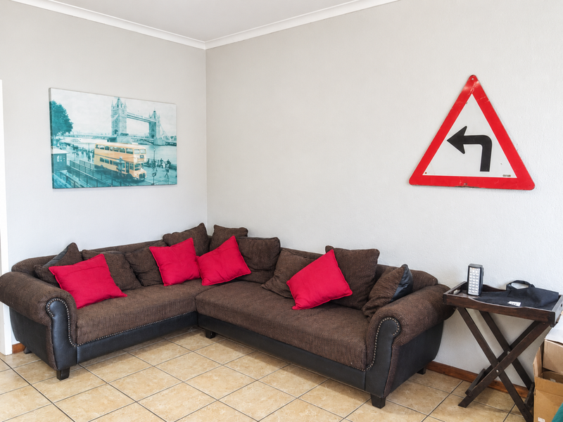A living room area featuring neutral walls and tiled flooring, providing a functional space for relaxation.