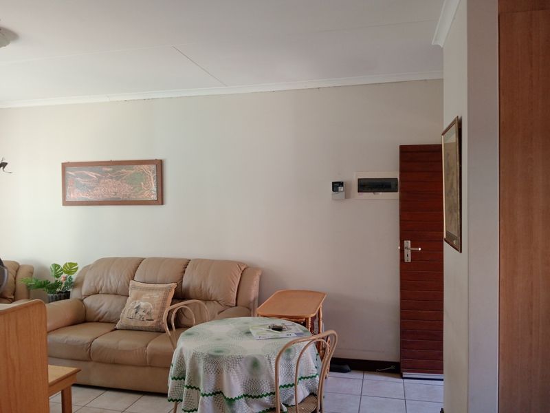 A living area featuring tiled flooring, a timber door, and integrated electrical services, providing a functional and neutral space.