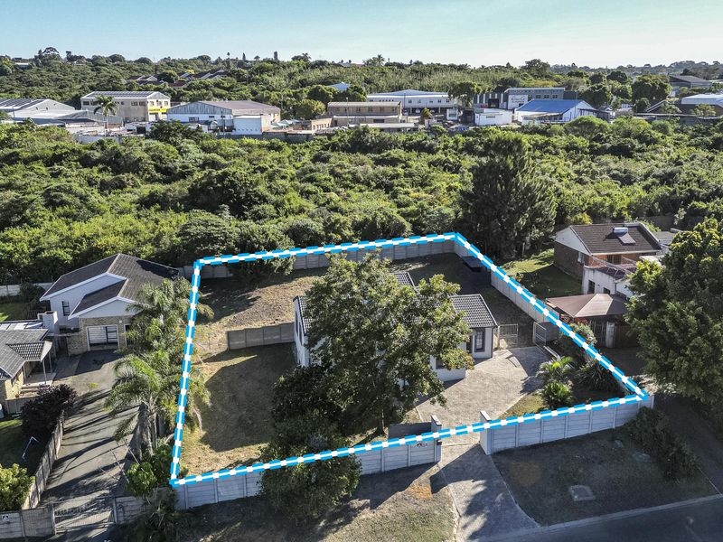 Aerial view of the property highlighting the plot boundaries, paved driveway, and surrounding residential area.