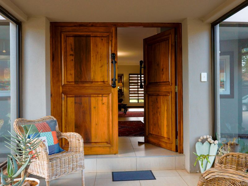 Inviting entrance featuring double solid timber doors and large glass side panels, providing a bright and welcoming transition into the home.