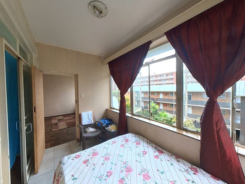 Enclosed balcony area featuring large windows, tiled flooring, and direct access to the interior living space.