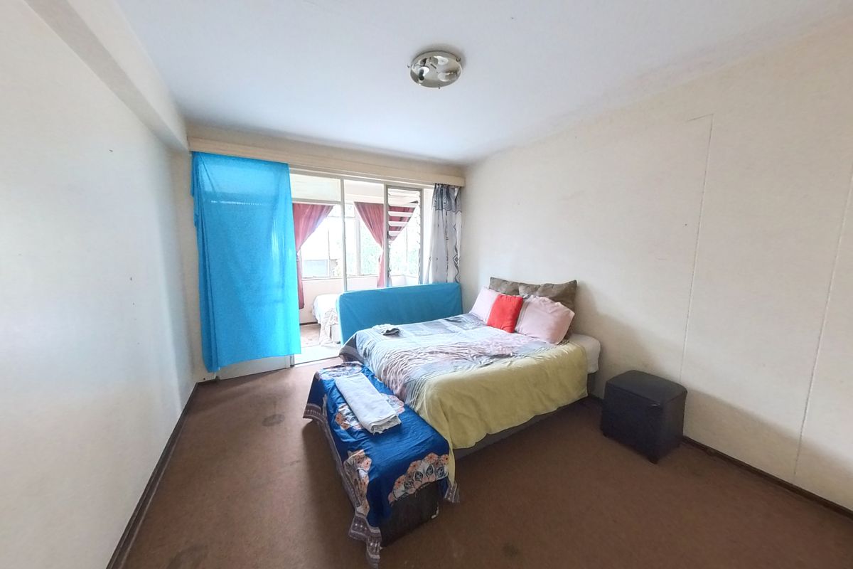 A bedroom featuring carpeted flooring and a sliding glass door providing access to an adjoining balcony area.