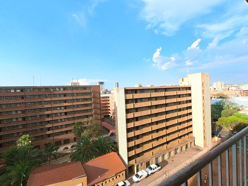 An elevated urban view from a balcony overlooking surrounding apartment buildings and residential infrastructure.