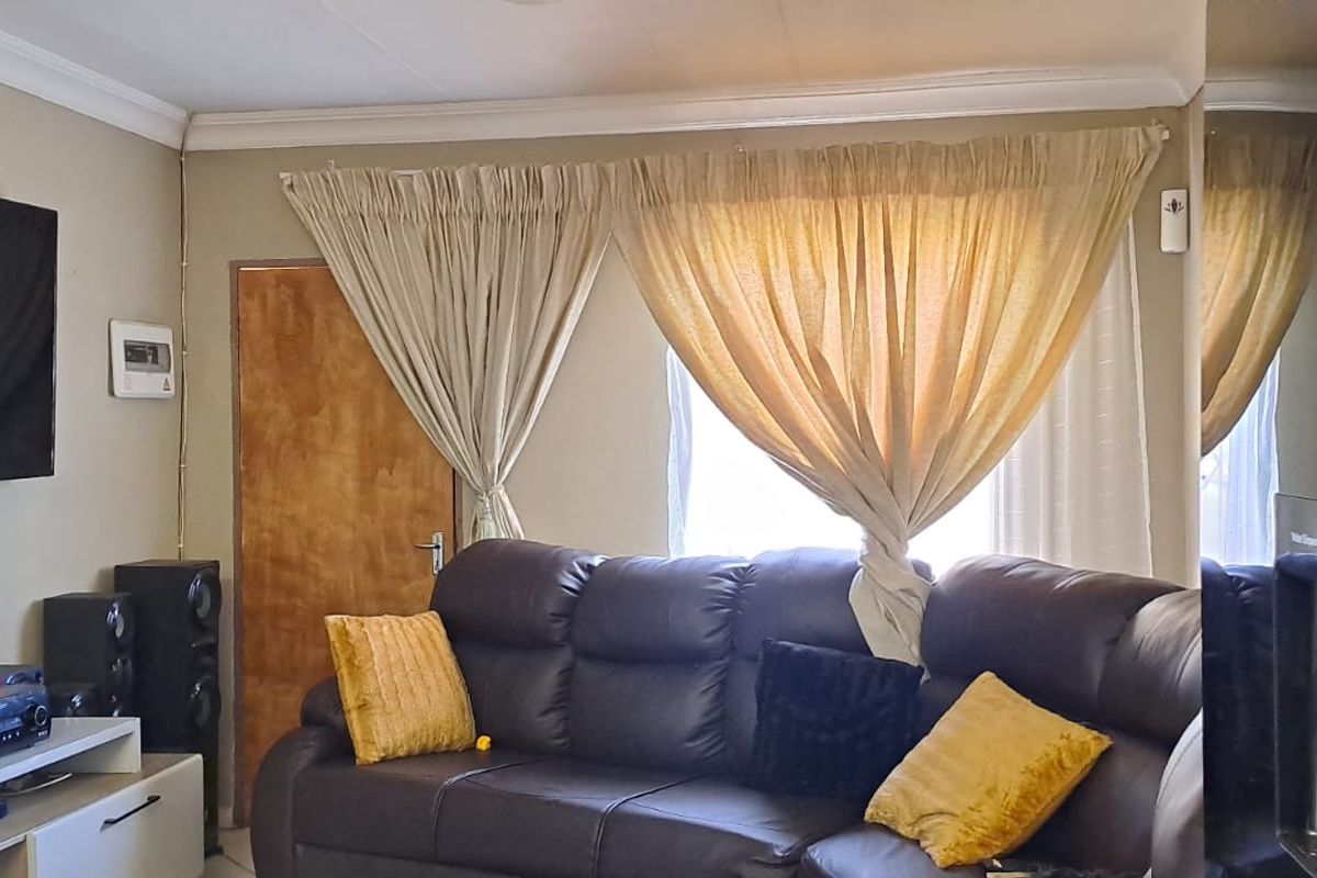 A living room featuring a wooden door and ceiling cornice detailing.