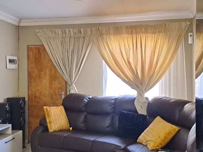 A living room featuring a wooden door and ceiling cornice detailing.