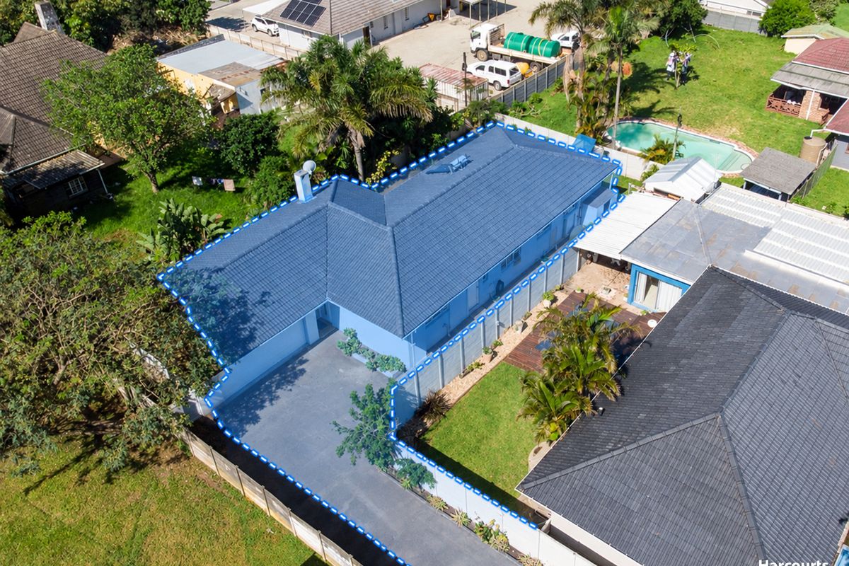 Aerial view of the property highlighting the tiled roof, concrete driveway, and surrounding boundary fencing within the residential plot.