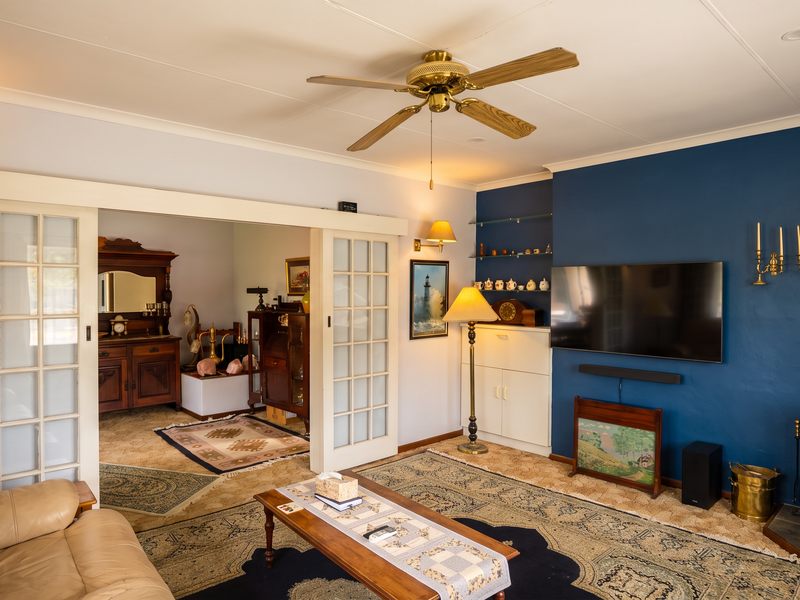 A cozy living room featuring a wood-burning stove, blue accent wall, and sliding glass doors leading to an adjacent room.