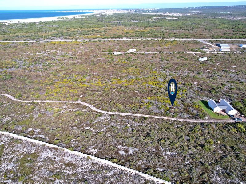 Aerial view of a large, undeveloped residential plot situated in a coastal landscape with nearby ocean views.