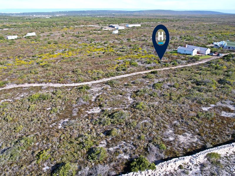 Aerial view of a large, undeveloped residential land parcel featuring native vegetation and a dirt access track.