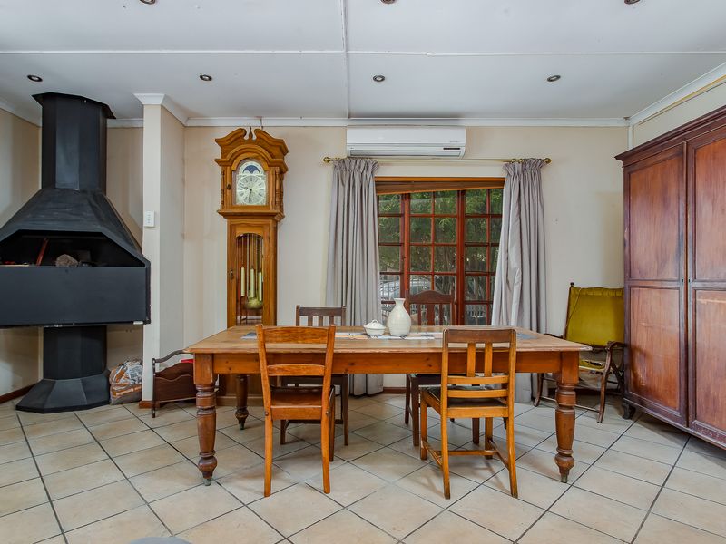 Dining room featuring tiled flooring, a built-in fireplace, and a split-system air conditioner, offering a functional space for family meals.
