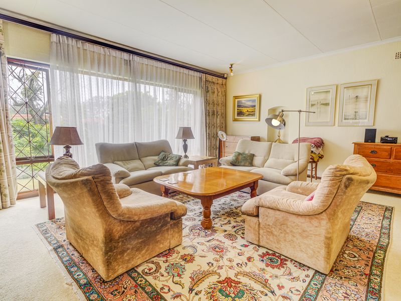 A spacious living room featuring large sliding glass doors with leaded window accents, providing ample natural light and access to the exterior.